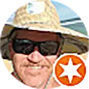 A man is spotted on the beach, sporting a straw hat and sunglasses, epitomizing the quintessential beach attire.